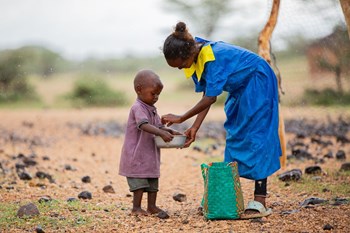 Adho teilt ihr Essen mit ihrer kleinen Schwester Sabdo.