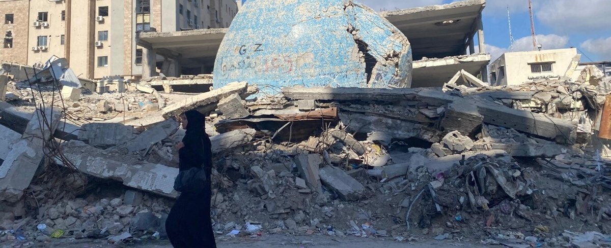 Eine Frau läuft durch Trümmer (Foto: Caritas Jerusalem)