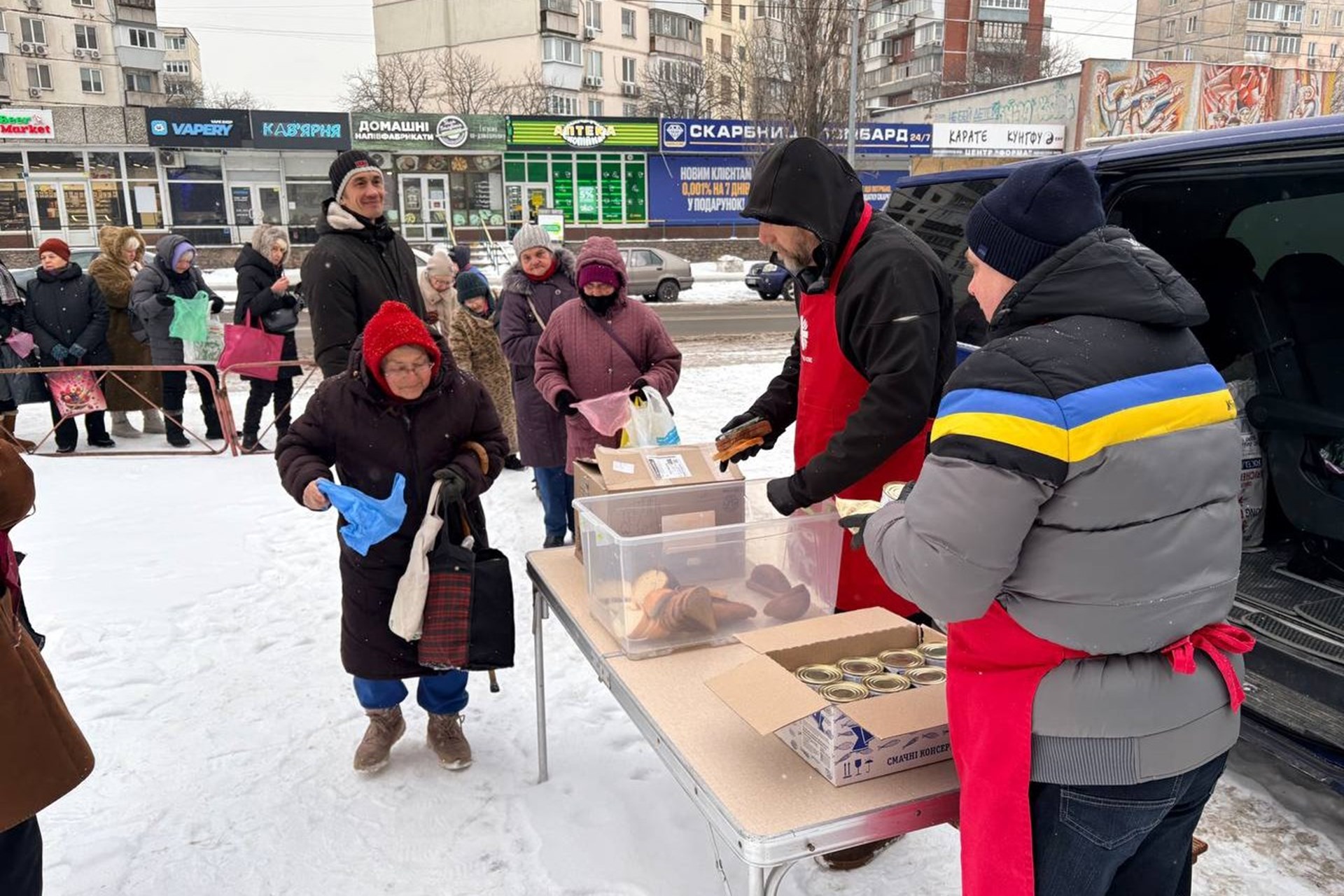 Caritas-Helfer verteilen Lebensmittel an Menschen in Kiew.
