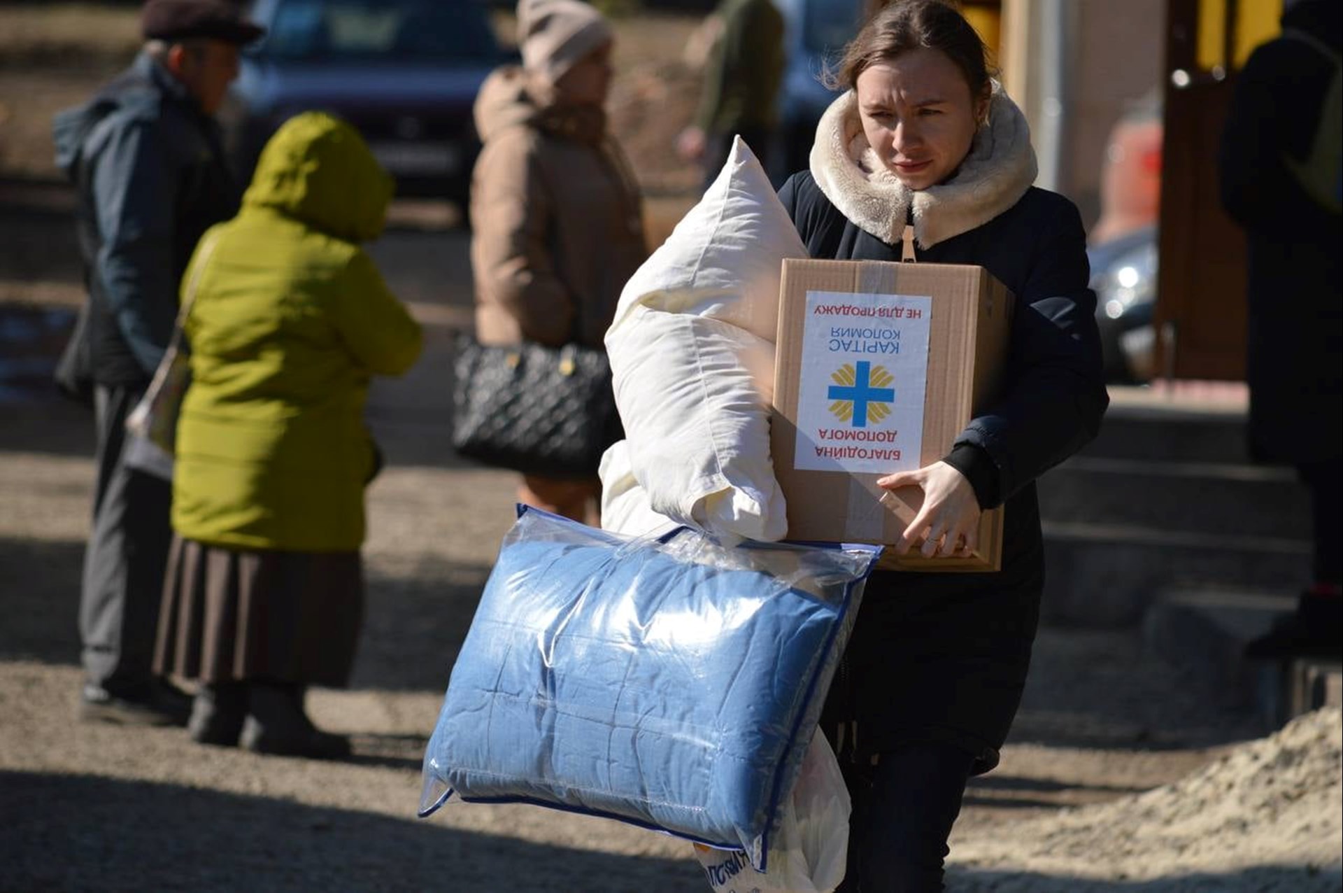 Eine Frau erhält ein Nothilfepaket der Caritas Ukraine