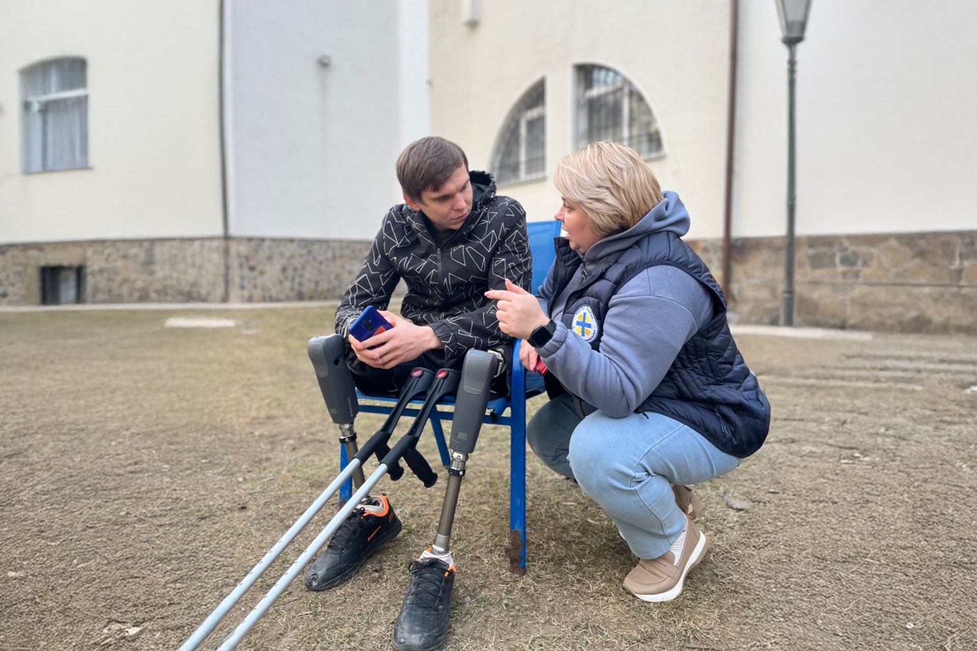 Ein junger Mann mit Beinprothesen und eine Caritas-Mitarbeiterin 