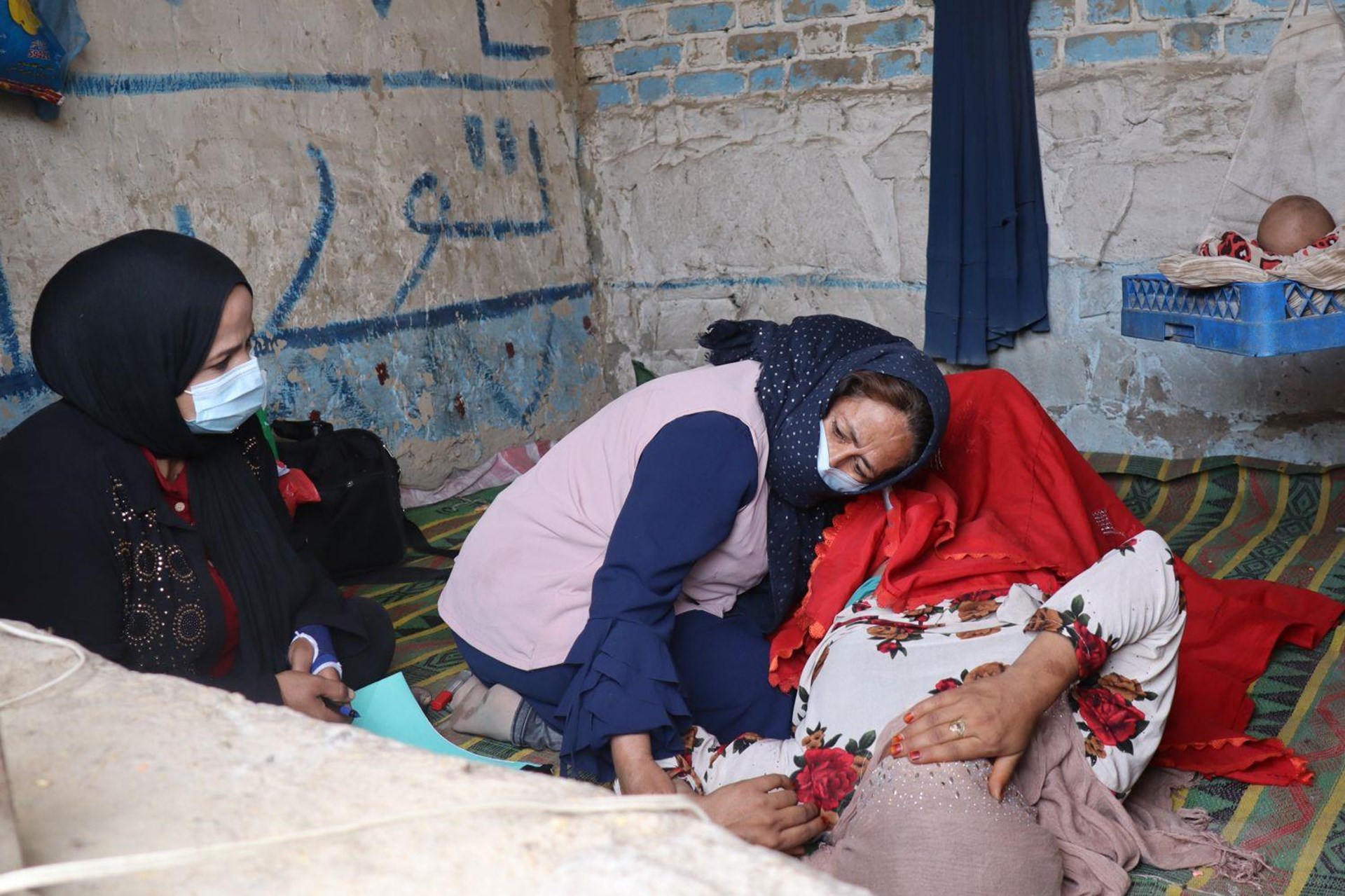 Eine Hebamme untersucht ihre Patientin