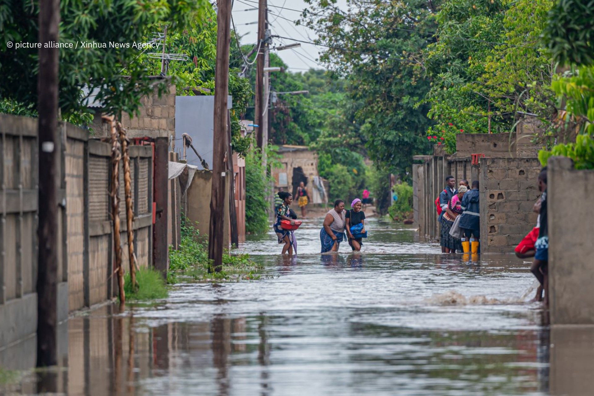 Einwohner waten durch das Hochwasser, das durch starke Regenfälle in Matola City, Provinz Maputo, Mosambik, am 12. Januar 2026 verursacht wurde.